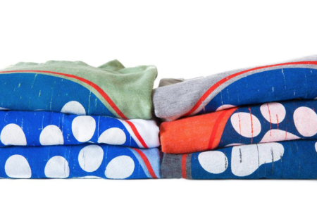 A pile of folded blankets with different designs.