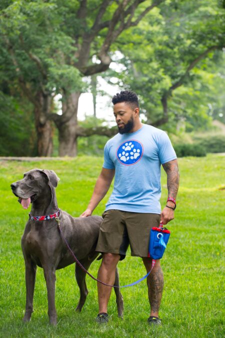 A man and his dog are walking in the park.