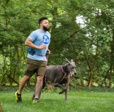 A man running with his dog in the park.