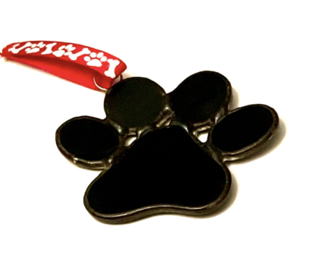 A black paw print ornament with red ribbon.