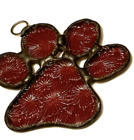 A red paw print with gold trim on top of it.