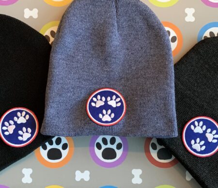 A beanie with paw prints on it and some other items