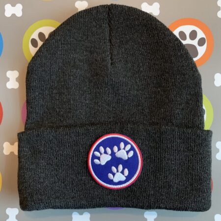 A black beanie with a paw print patch on it.