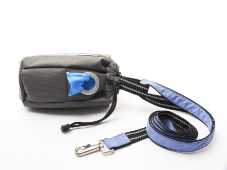 A black and blue dog leash laying on top of a white table.