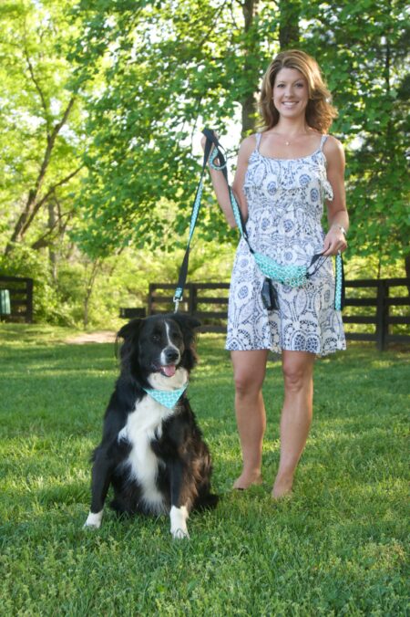 A woman and her dog in the grass.